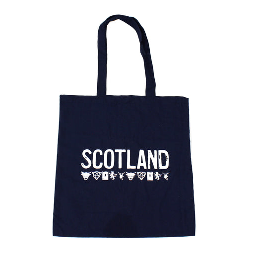 blue cotton tote bag with word scotland printed in white across middle with small icons pattern below including highland cow, castle, stag and lion