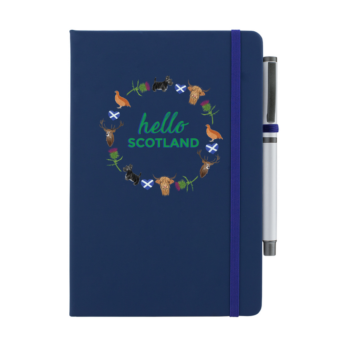 Navy notepad with pen features a circular prints of Scottish Icons including the St Andrews Flag in a loveheart shape, a pheasant and a deer. A matching strap closes on the right hand side.