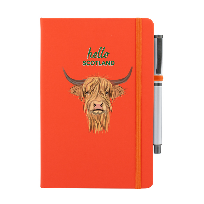 Orange soft feel note pad with a highland cow motif. the text above reads 'hello SCOTLAND' and comes with a silver pen attached.