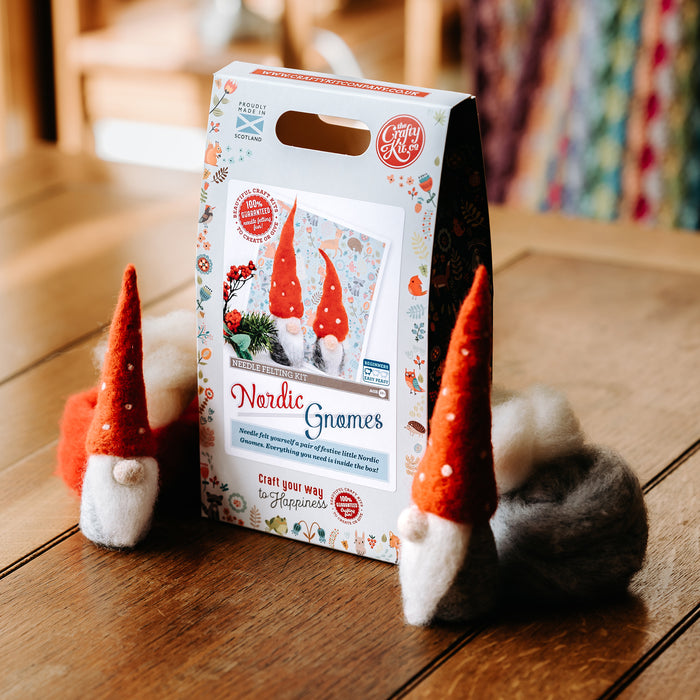 Nordic Gnomes Felt kit box placed on a table next to the made up felted gnomes