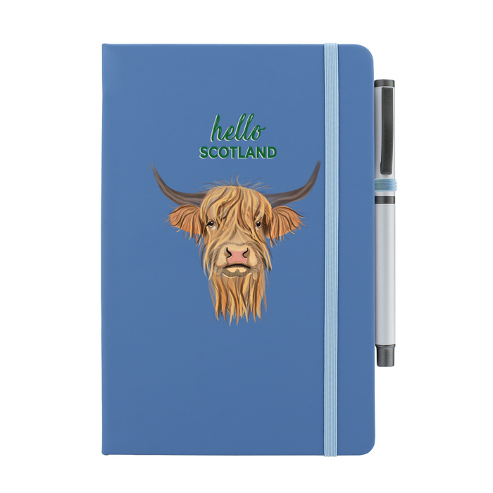 Blue soft feel note pad with a highland cow motif. the text above reads 'hello SCOTLAND' and comes with a silver pen attached.