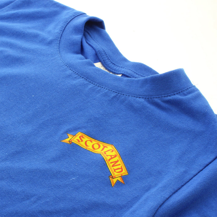 Close up of the front of a blue tshirt featuring a yellow design with the word 'SCOTALAND'.