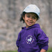 Child wears a purple Hoodie depicting and a blue cap, both have a Unicorn design on the front. 