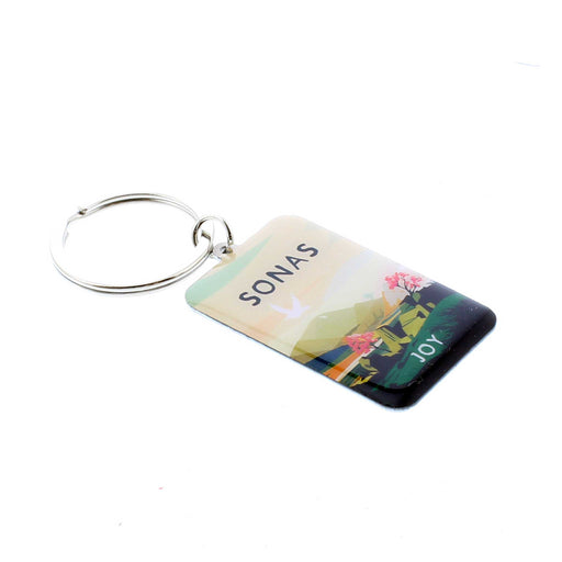 Small enamel keyring with silver hardware. The keyring features a print of a landscape at sunset, the text reads 'sonas' which is Gaelic for joy. 