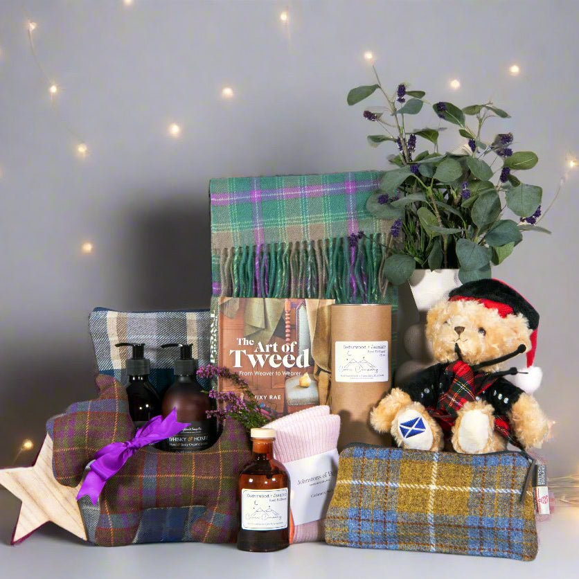 Collection of tartan textiles, books and gifts against a fairy lit background - Image