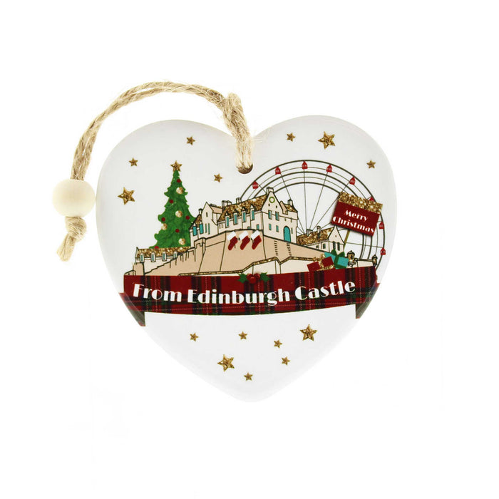 White Ceramic Tree decoration in a love heart shape. The decoration features a depiction of Edinburgh Castle at Christmas which features a Christmas tree, big wheel, gold stars and a red tartan banner at the bottom with white text that reads 'From Edinburgh Castle'. 