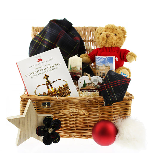 A wicker hamper filled with Edinburgh Castle merchandise including a book, tartan textiles, a teddy bear, homewares and card game. 