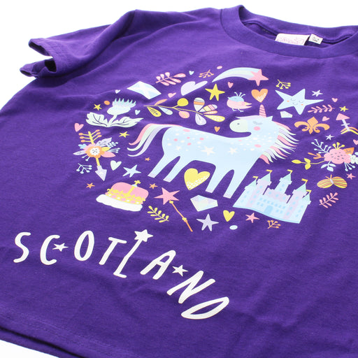 Close up of the front of the purple Enchanted T-Shirt that features a whimsical scene of a Unicorn surrounded by stars, castles and royal emblems. 