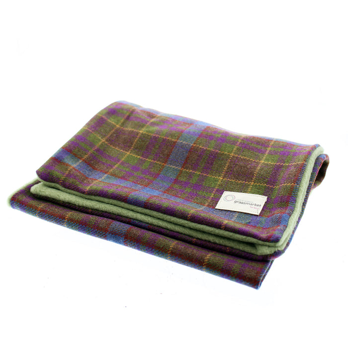 Tartan Scarf in a green, blue and purple weave that is exclusive to the local Grassmarket Tartan. The scarf is folded neatly against a white backdrop. 