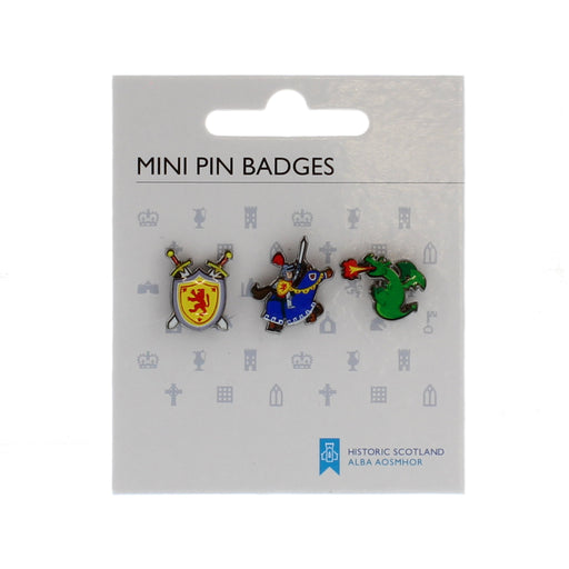 White card holding 3 small pin badges ; a lion rampant shield, a knight on a horse and a fire breathing dragon. 