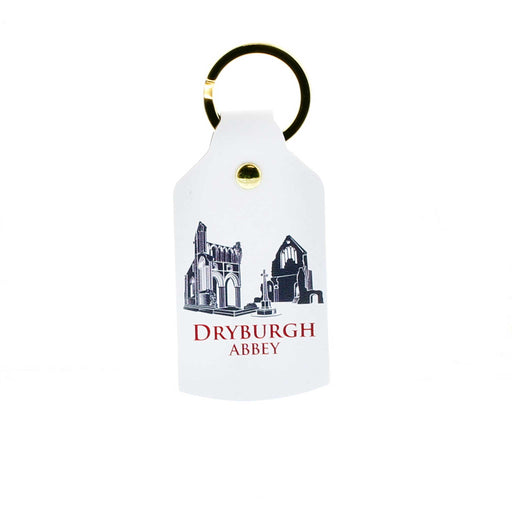 White leather oblong shaped keyring with gold hardware. The print shows a greyscale image of Dryburgh Castle, underneath the text reads the castle name in red.