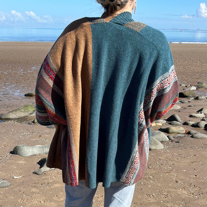 Person stands looking out to the sea wearing the Lugano Cardigan 