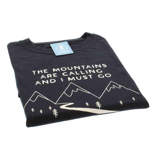 Black folded t-shirt with the phrase 'The mountains are calling and I must go' above an outlined print of snow-top mountains. 