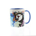 White ceramic mug with a depiction of a Puffin holding a fish infront of a seaside town. 