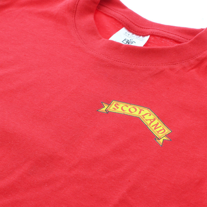 Close up of the front of the red t-shirt which features a yellow label reading SCOTLAND