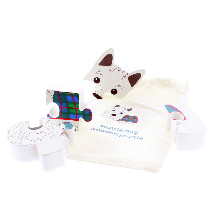 White Wooden toy puzzle in the shape of a Scottie Dog with a tartan coat. The puzzle is briken up into 4 pieces and laid on it's carry bag. 