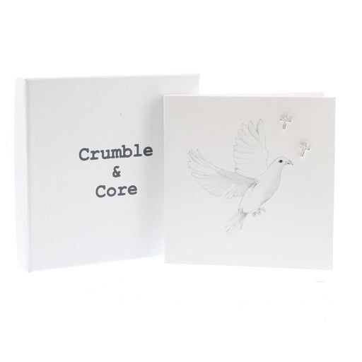 White card with a print of a white dove in flight. The card has a pair of silver cross earrings in the top right hand corner.  A white package box is to the left and the text reads 'Crumble & Core'. 