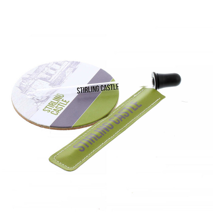 The Stirling Castle Whisky Pipette is a clear dropper wit the words 'Stirling Castle' written in black. The Pipette holder is a green leather with white stitching which also has Stirling Castle printed on the front. Next to the pipette is the matching Stirling Castle Leather Coaster featuring a sketch of the Castle above a green and grey striped bottom. 