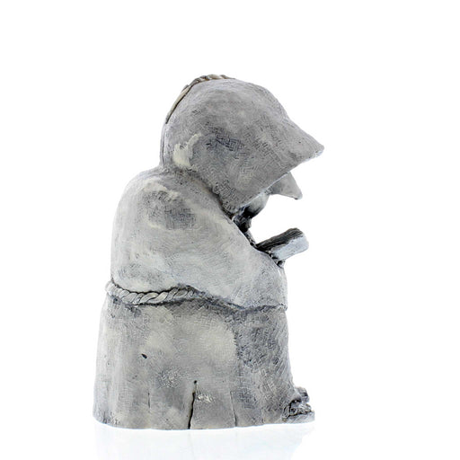 Stone garden ornament depicting a monk reading from a journal.