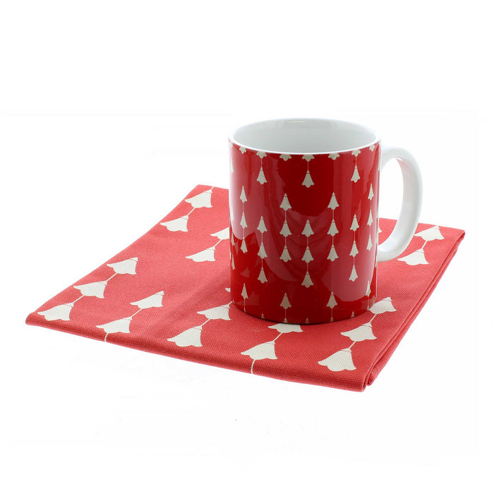 red and white coffee mug on folded matching napkin