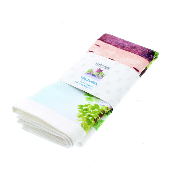 White cotton tea towel featuring a bright coloured print of Urquhart Castle on the banks of Loch Ness.