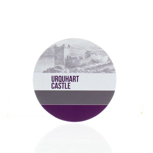 The round leather Urquhart Castle Coaster features a sketch of the castle at the top with the words 'Urquhart Castle' underneath. This is followed by a grey then purple stripe. 