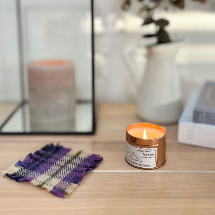 Coorie Tartan Coaster placed next to a candle and books 