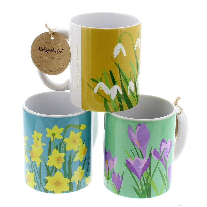 Trio of brightly coloured mugs featuring a daffodil print, snowdrop print and a crocus print. 