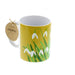 Yellow ceramic mug with a white snowdrop print. 
