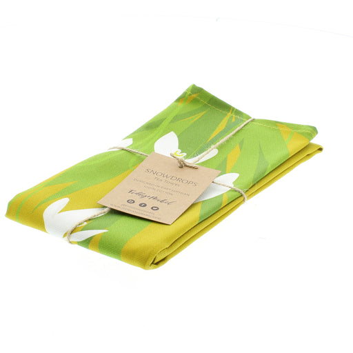 Yellow tea towel with a white and green snowdrop print. 
