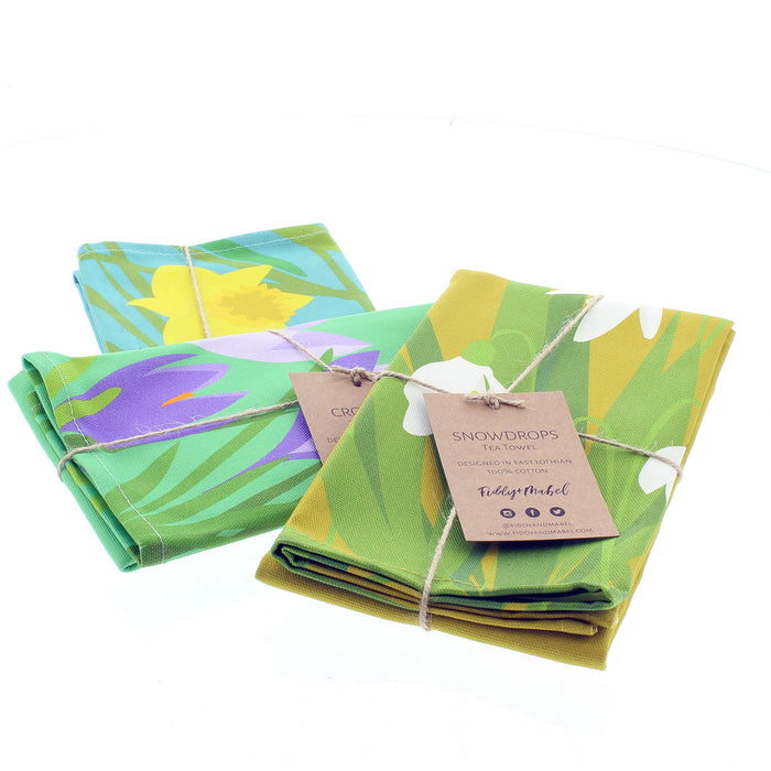 Trio of brightly coloured tea towels with a daffodil print, crocus print and a snowdrop print. 