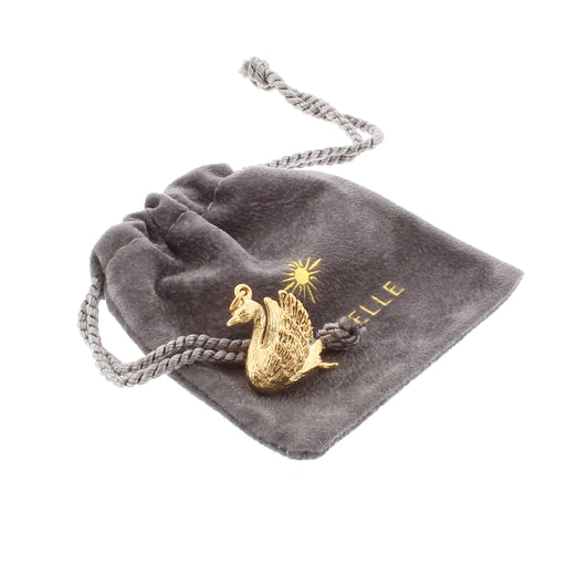 Gold Plated Swan shaped charm sitting on it's own personal grey velvet pouch with drawstring closure. 
