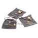 Selection of Gold Charms placed on grey velvet pouches include an orb, swan and thistle. 