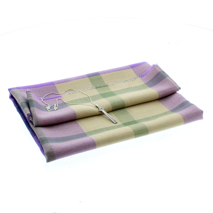 The Silver Maclean Cross Pendant and necklace placed on a folded purple and green tartan scarf
