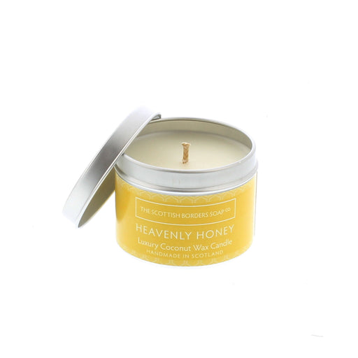 Silver candle tin with a yellow label contains a honey scented candle.