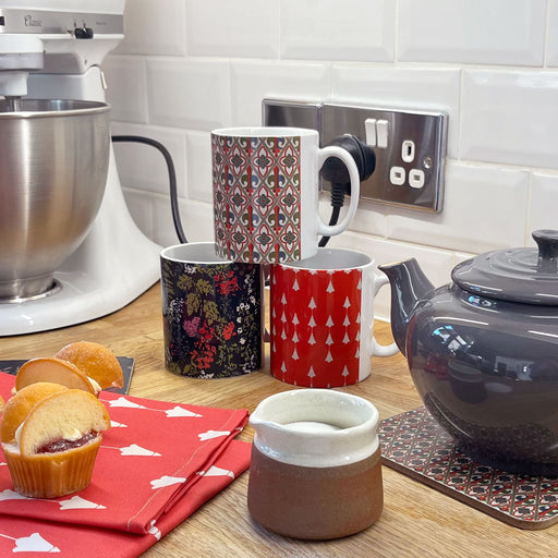 A kitchen scene highlights the three Stirling Castle mugs next to a teapot, tulip teatowels, sugar bowl, food mixer and freshly baked cupcakes. 