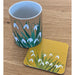 Snowdrop printed mug and coaster placed on a wooden kitchen worktop