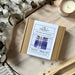 Tartan Coaster Kit boxed next to a candle, dried eucalyptus and sheepskin rug