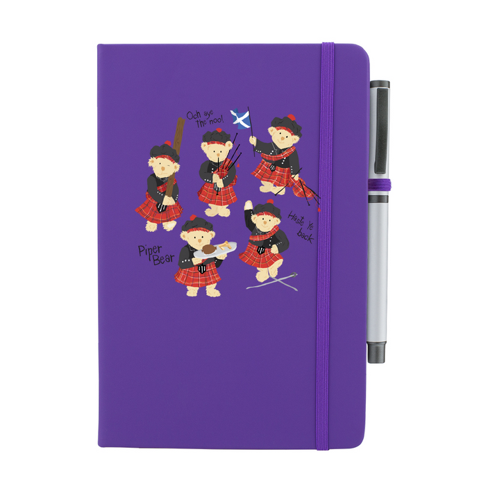 A beautiful designed purple notebook featuring a vibrant illustration of dancing piper bears in red and black, playing bagpipes joyfully. A purple strap closes over the right hand side with a matching pen.