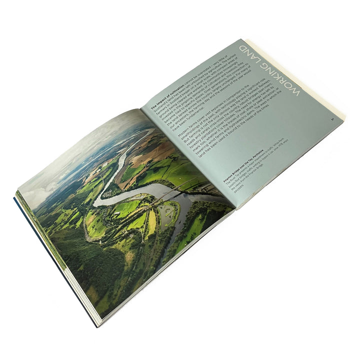 book shown open at page titled working land with text and colour image of landscape from above and winding river through farmland