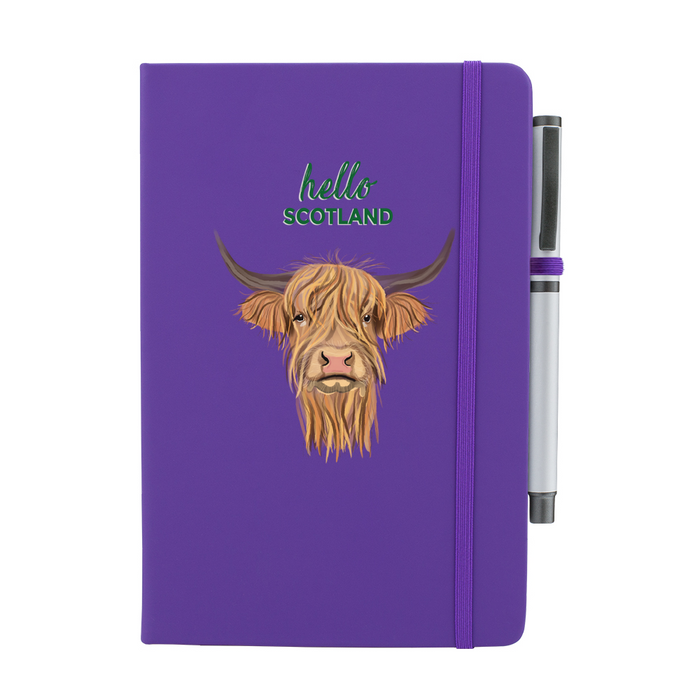 Purple soft feel note pad with a highland cow motif. the text above reads 'hello SCOTLAND' and comes with a silver pen attached.