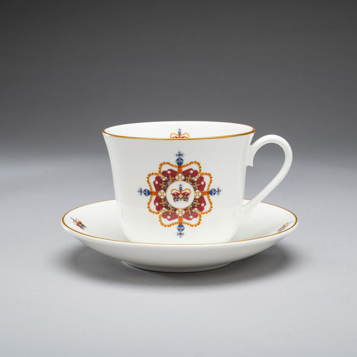 Edinburgh castle crown fine bone china tea cup and saucer shown on grey background. the design has a central crown and stylized pattern