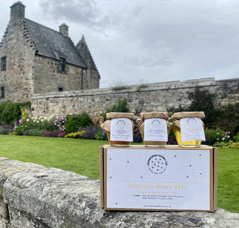 view of aberdour castle with edinburgh honey gift set on wall in garden