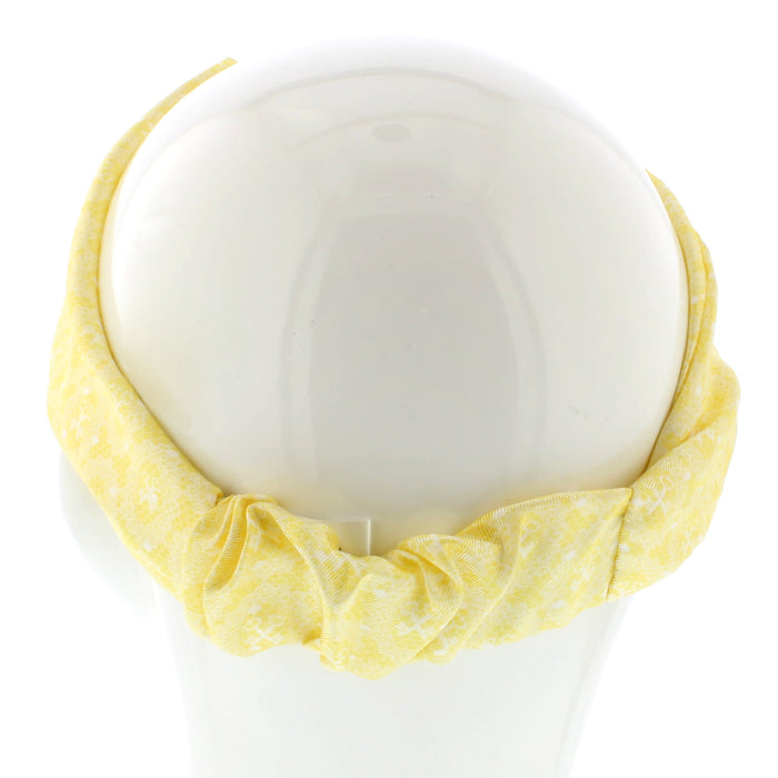White mannequin head shows a lace print headband in yellow and white 