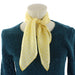 White mannequin showcasing the lace keys print neck silk neck scarf in yellow and white