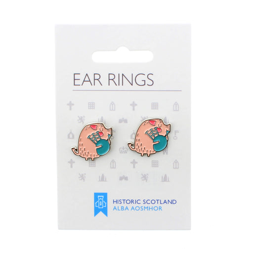 pair of pink enamel earrings featuring a pig playing the bagpipes