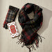 Black and red plaid scarf with matching gloves and a card on a white background - Image