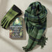 Green plaid scarf, gloves, and book titled 'Embroidering Her Truth' by Clare Hunter on a white background. - Image