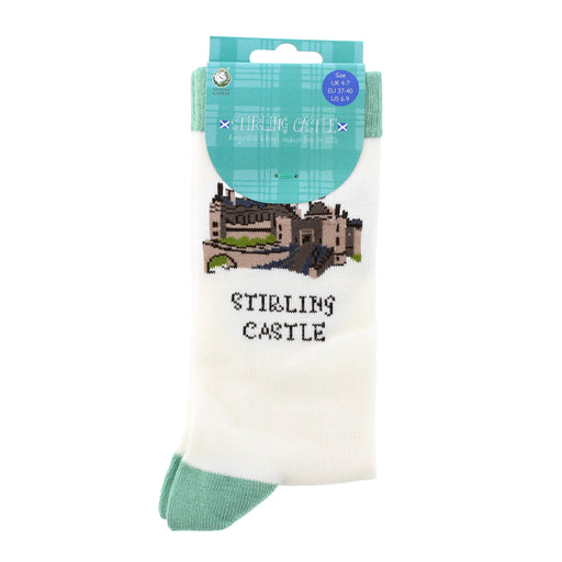A pair of white crew socks in retail packaging, featuring an embroidered illustration of Stirling Castle and the text 'STIRLING CASTLE' on the front, with a teal plaid header card. - Image
