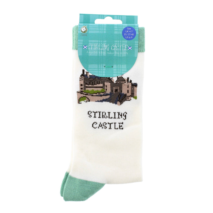A pair of white crew socks in retail packaging, featuring an embroidered illustration of Stirling Castle and the text 'STIRLING CASTLE' on the front, with a teal plaid header card. - Image